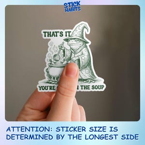 May include: A green and white sticker featuring a frog wizard stirring a cauldron. Text on the sticker reads "THAT'S IT, YOU'RE I THE SOUP." The sticker has the "Stick Habits" logo in the top right corner. The sticker's size is determined by the longest side.