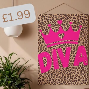 Op de afbeelding: Een rechthoekige wandkunstprint met een bruin en zwart luipaardpatroon. Een felroze afbeelding van een kroon met kleine hartjes staat boven het woord DIVA in grote, dikke, roze hoofdletters. De tekst £1.99 is zichtbaar.