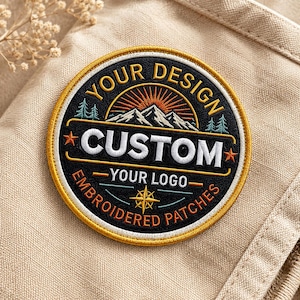 Könnte beinhalten: Runder, gestickter Aufnäher mit schwarzem Hintergrund und gelbem Rand. Der Aufnäher zeigt den Text "YOUR DESIGN CUSTOM YOUR LOGO EMBROIDERED PATCHES". Eine Berg- und Sonnengrafik befindet sich in der Mitte.
