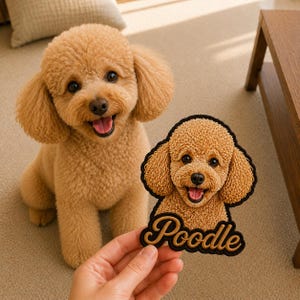 May include: A smiling apricot-colored poodle sits next to a poodle-shaped patch held by a hand. The patch has a black border and the word "Poodle" in a cursive font. The dog and patch share a similar appearance.