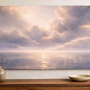 Könnte beinhalten: Ein großer rechteckiger Leinwanddruck, der eine ruhige Meereslandschaft mit einem bewölkten Himmel zeigt. Das Kunstwerk weist weiche Pastellfarben auf, wobei sich die Sonne auf der Wasseroberfläche spiegelt. Eine dekorative Vase und eine Schale stehen auf einer Holzoberfläche.