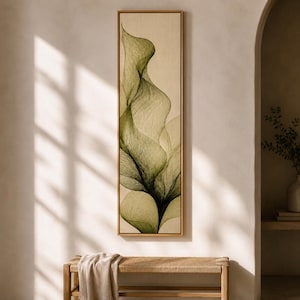 May include: A tall, rectangular wall art piece featuring an abstract, flowing botanical design in shades of olive green and dark forest green against a cream-coloured background, enclosed within a thin, light-toned wooden frame.