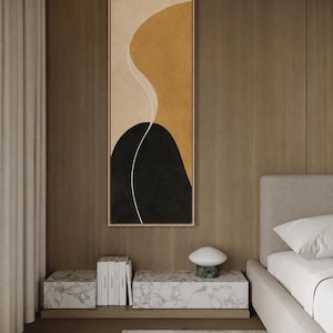 May include: A vertical rectangular framed wall art piece featuring an abstract composition with a large mustard yellow curved shape, a solid black rounded form at the bottom, and a thin white line separating the two against a beige background.
