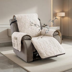 Könnte beinhalten: Eine beige gesteppte Relaxsessel-Abdeckung mit wasserabweisendem Design. Die Abdeckung hat ein dekoratives Muster und Taschen an der Armlehne. Sie ist über einem grauen Relaxsessel drapiert und schützt vor Spritzern und Flecken.