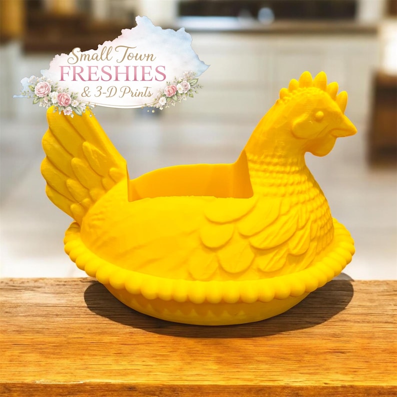 May include: A bright yellow hen-shaped container, possibly a decorative egg holder or planter. The hen is sitting on a nest-like base with a ruffled edge. The image includes the text "Small Town Freshies & 3-D Prints".