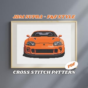 Puede incluir: Patrón de punto de cruz de un coche JDM Supra naranja en un marco. El texto "JDM SUPRA - F&F STYLE" está encima del coche, y "CROSS STITCH PATTERN" debajo. Un icono "PDF" está en la esquina inferior derecha.