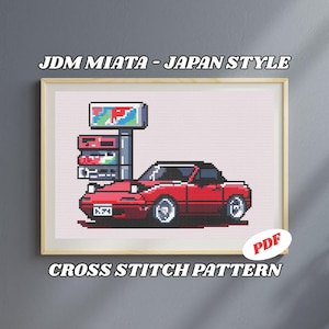 以下が含まれることがあります： 赤いJDM Miata車をピクセル化したスタイルの額入りクロスステッチパターン。ガソリンスタンドの看板があります。「JDM MIATA - JAPAN STYLE」と「CROSS STITCH PATTERN」の文字が表示されています。右下隅にPDFアイコンがあります。