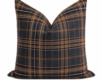 Peut inclure: Un coussin carré avec un motif à carreaux gris anthracite foncé, marron et blanc. Le tissu présente une texture tissée visible avec des lignes horizontales et verticales qui se croisent pour former un motif à grille sur toute la surface.
