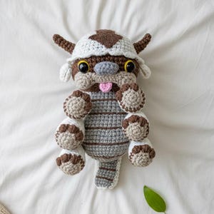 May include: A white ceramic mug with a black handle and the text "But First, Coffee" in a handwritten style. The mug is on a white surface. The mug is approximately 4 inches tall.