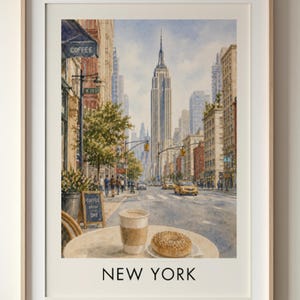 May include: Watercolor print of a New York City street scene featuring the Empire State Building. A table in the foreground displays a coffee cup and a donut. The word "NEW YORK" is printed at the bottom.