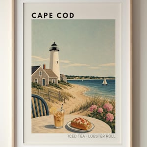 Könnte beinhalten: Ein gerahmtes Reiseplakat mit der Aufschrift CAPE COD zeigt eine Küstenszene mit einem weißen Leuchtturm, einem Sandstrand, einem Segelboot und einem Tisch im Vordergrund mit Eistee mit Zitronenscheibe und einem Lobster Roll, beschriftet ICED TEA LOBSTER ROLL.