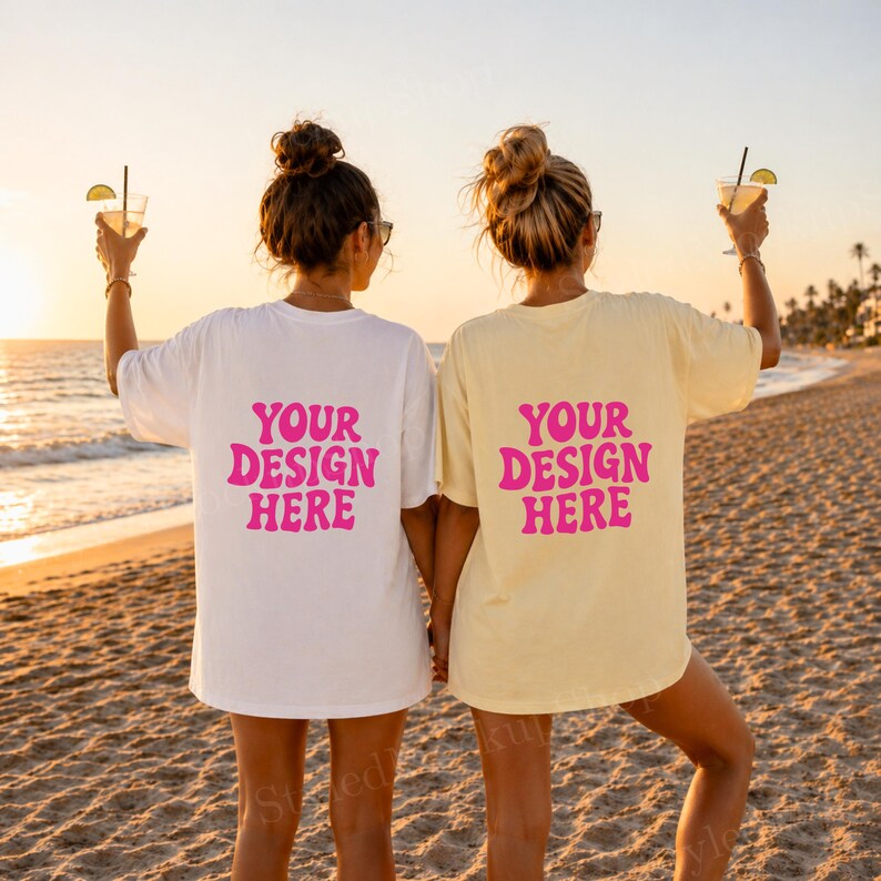 Puede incluir: Dos personas con camisetas blancas y amarillas con el texto "YOUR DESIGN HERE" en rosa. Est&aacute;n en una playa de arena al atardecer, sosteniendo c&oacute;cteles. Las camisetas son de gran tama&ntilde;o.