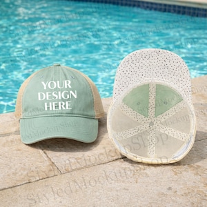 Puede incluir: Dos gorras de béisbol, una verde azulado y otra con la parte inferior visible. La gorra verde azulado tiene una parte trasera de malla y el texto "YOUR DESIGN HERE" en blanco. La parte inferior de la otra gorra es blanca con lunares negros.