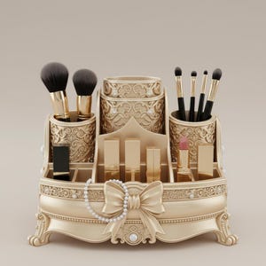 May include: A gold-colored makeup organizer with ornate detailing, holding makeup brushes, lipsticks, and other beauty products. The organizer features a bow and pearl accents, adding a touch of elegance.