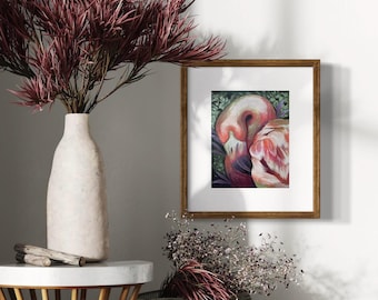 May include: A framed artwork featuring two pink flamingos with a green background. The artwork is in a brown wooden frame. A white vase with burgundy-colored branches sits on a small table. A woven basket with dried flowers is also visible.