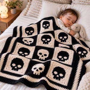 May include: A handmade crochet baby blanket featuring a repeating pattern of black skulls on a cream-colored background. The blanket is constructed from individual square motifs joined together, creating a high-contrast graphic design.
