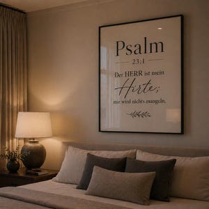 Może przedstawiać: Wnętrze sypialni z oprawionym wydrukiem z tekstem "Psalm 23:1". Wydruk wisi nad łóżkiem z poduszkami i pościelą w neutralnych odcieniach. Lampa nocna z okrągłą podstawą i mały wazon z zielenią znajdują się na stoliku nocnym.