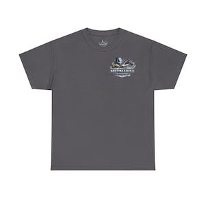 Può includere: T-shirt grigio scuro con una piccola grafica sulla parte superiore sinistra del petto. La grafica raffigura strumenti di saldatura e la parola "Metallbau" in un font stilizzato. La maglietta è realizzata in un materiale morbido e confortevole.