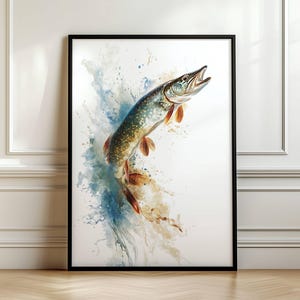 May include: A framed watercolour print of a Northern Pike fish leaping upwards. The fish is depicted with detailed scales and fins in shades of green, brown, and orange, set against a backdrop of blue and beige watercolour splashes. The artwork is encased in a black frame.