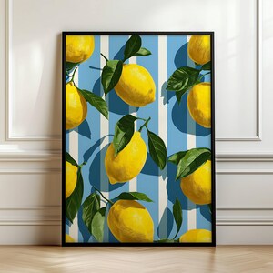 May include: A framed art print featuring a pattern of bright yellow lemons with green leaves against a blue and white striped background. The artwork is displayed in a black frame, creating a vibrant and summery aesthetic.
