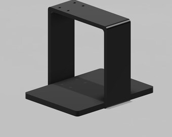 Puede incluir: Un soporte rectangular negro con un diseño en forma de U. El soporte tiene una base plana y una sección superior con cuatro pequeños agujeros. La forma general es moderna y minimalista, adecuada para montaje o soporte.