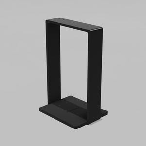 May include: A matte black metal stand featuring a rectangular base and a tall, vertical U-shaped frame. The structure has a flat top bar with two small circular holes and a solid, flat rectangular base plate, providing a stable, open-frame design.