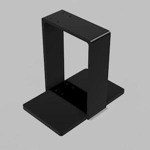 May include: A black metal stand with a rectangular base and a vertical, U-shaped support. The stand has a matte finish and appears to be made of solid metal. The design is minimalist and modern.