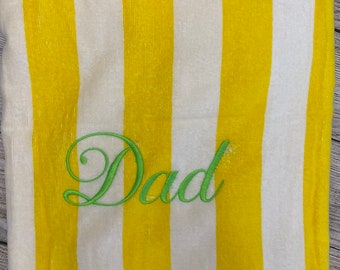 May include: Yellow and white striped beach towel with the word "Dad" embroidered in green.