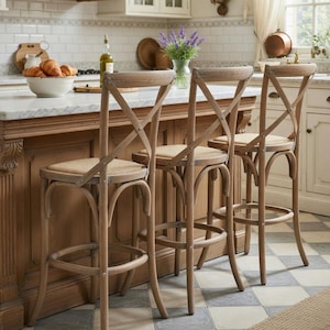 May include: Three wooden bar stools with woven seats and an X-shaped backrest. The stools have a curved design and a footrest. The stools are in a kitchen setting with a marble countertop and a wooden island.