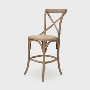 Puede incluir: Un taburete de bar de madera marr&oacute;n claro con respaldo en forma de X y asiento tejido. El taburete tiene patas curvas y reposapi&eacute;s. El dise&ntilde;o es r&uacute;stico y de estilo campestre.