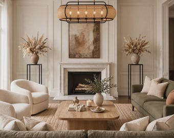 May include: An elongated oval chandelier featuring a black metal frame and woven cane panels. The fixture contains five internal light bulbs and is suspended by thin chains, providing illumination over a living room seating area.