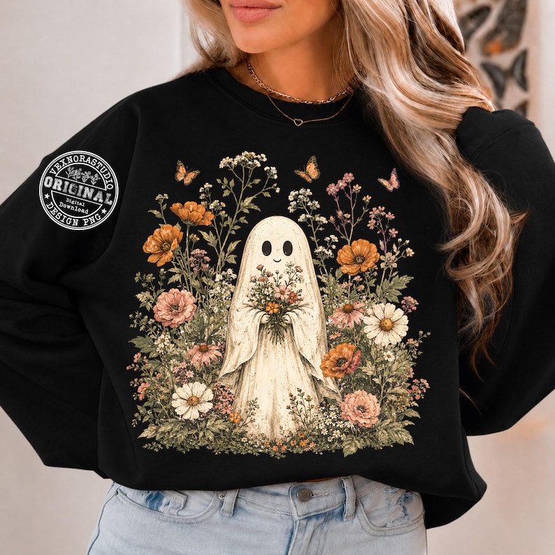 Pu&ograve; includere: Una felpa nera a maniche lunghe con una grafica centrale di un fantasma bianco che tiene un bouquet di fiori, circondato da vari fiori di campo colorati e farfalle. &Egrave; visibile un logo circolare con il testo VEXNORSTUDIO ORIGINAL DESIGN PNG.