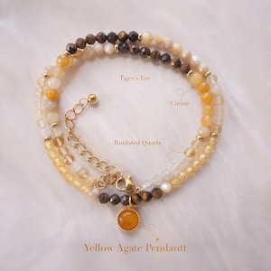 May include: A layered bracelet featuring Tiger's Eye, Citrine, and Rutilated Quartz beads. The bracelet includes a Yellow Agate Pendant and gold-colored metal accents. The text on the image indicates the type of stones used.