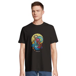 May include: A black short-sleeve t-shirt featuring a central graphic design with abstract shapes in blue, red, and yellow, surrounded by a yellow sunburst pattern. The text "Youkaya Art" is printed in small white letters below the graphic.
