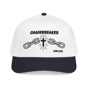 May include: A white baseball cap with a navy blue brim and a black button. The cap features the text "CHAINBREAKER" above a graphic of a cross and broken chains, with "JOHN 8:36" below.