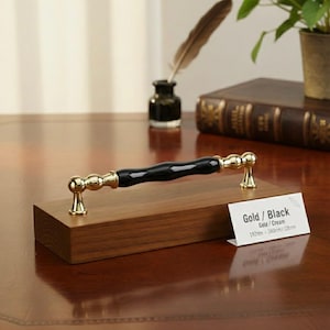 Op de afbeelding: Een set van drie keramische mokken met een gespikkelde, matte afwerking. De mokken zijn in de kleuren crème, lichtgrijs en donkergrijs. Elke mok heeft een eenvoudig, modern ontwerp en een afgeronde handgreep. De mokken zijn op elkaar gestapeld.