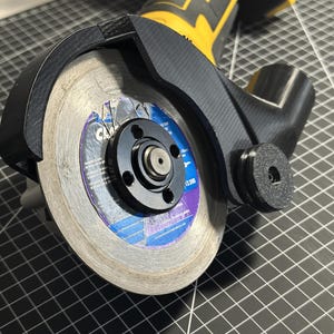 May include: A black and yellow cordless angle grinder with a circular cutting blade. The blade is silver with blue and purple accents. The grinder has a black protective guard.