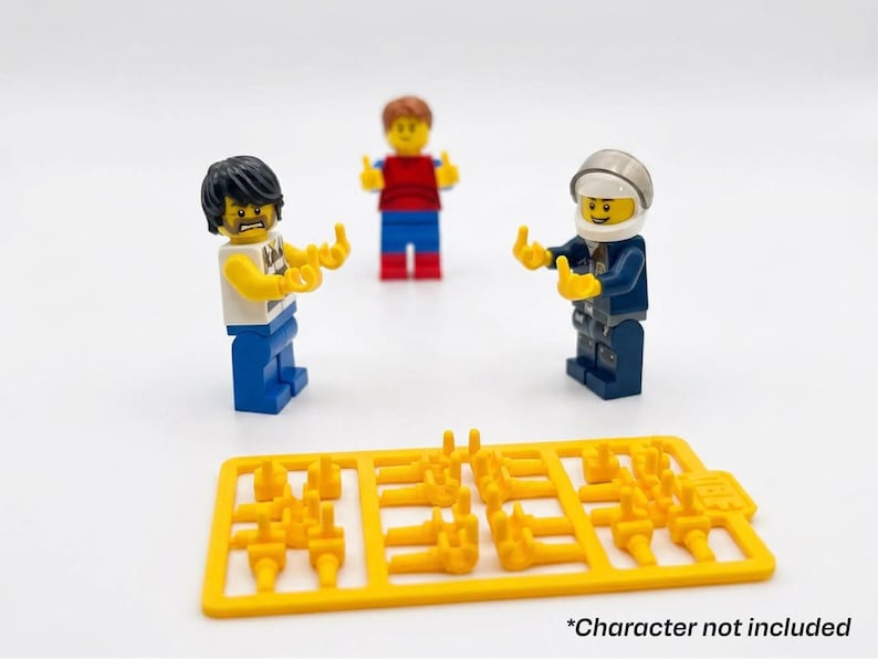 Może przedstawiać: Trzy minifigurki Lego w r&oacute;żnych strojach i z r&oacute;żnymi wyrazami twarzy. Jedna z figurek ma na sobie niebieski mundur i hełm. Ż&oacute;łty plastikowy wlew z kilkoma małymi elementami dłoni znajduje się na pierwszym planie. Tekst na dole brzmi "*Character not included".