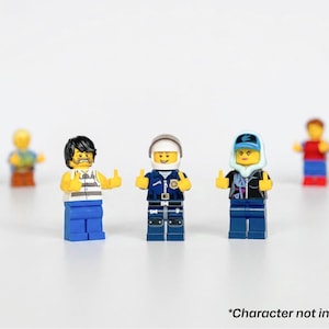 Może przedstawiać: Kolekcja figurek Lego, w tym więzień, policjant i kobieta w kurtce i czapce. Figurki stoją w rzędzie, z tekstem "*Character not included" na dole.