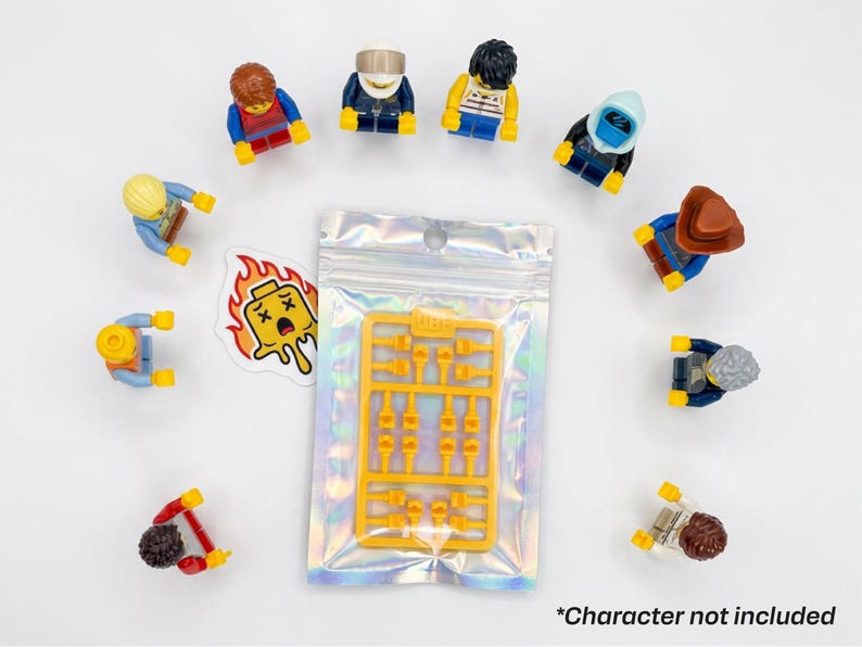 Może przedstawiać: Kolekcja kolorowych figurek Lego ułożonych w okrąg wok&oacute;ł zamkniętej holograficznej torby zawierającej ż&oacute;łte akcesoria Lego. Obecna jest r&oacute;wnież naklejka z płonącą głową Lego. Tekst "*Character not included" znajduje się na dole.