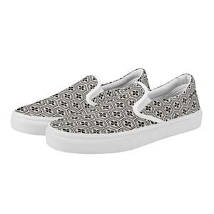 Peut inclure: Paire de baskets à enfiler avec un motif géométrique noir et blanc. Les chaussures ont une semelle blanche et une bordure blanche autour de l'ouverture. Le motif est une répétition d'hexagones et de formes florales.