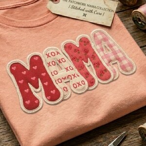 Könnte beinhalten: Ein pfirsichfarbenes T-Shirt mit dem Wort MAMA in großen, aus Stoff applizierten Buchstaben mit roten Herz-, weißen XOXO-, roten Blumen- und rosa Vichy-Karomustern. Ein rechteckiges Etikett am Kragen trägt die Aufschrift The Patchwork Mama Collection.