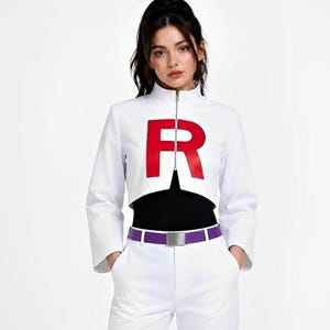 May include: A white cropped jacket with a high collar and a large red letter R on the chest, worn over a black top. The outfit includes white trousers and a purple belt with a silver buckle, creating a coordinated ensemble with a clean aesthetic.
