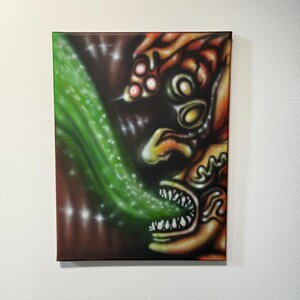 Puede incluir: Una pintura sobre lienzo que presenta un monstruo estilizado con detalles en naranja, amarillo y blanco. Una corriente verde y punteada emana de la boca del monstruo. El fondo es marrón oscuro con reflejos blancos, creando una obra de arte fantástica surrealista.