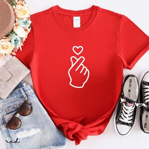 Aesthetic finger heart design shirt with modern line art, ideal for casual wear and subtle love expression