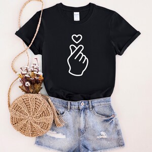 Minimalist t-shirt with Korean finger heart symbol, simple love graphic design for everyday casual wear