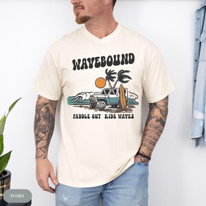 Retro surf themed t-shirt design featuring a 4x4 beach vehicle, surfboard, ocean waves, palm trees and sun with the text Wavebound Surf Club.