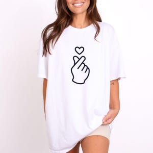 Cute finger heart shirt featuring clean line art, perfect for romantic style and modern minimal outfits