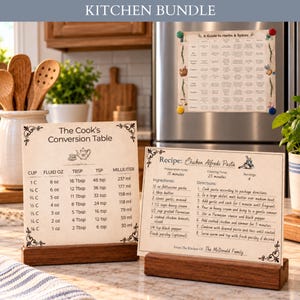 May include: A kitchen bundle featuring three printed cards with a vintage paper aesthetic. One card is a conversion table, one is a chicken alfredo pasta recipe, and one is a guide to herbs and spices, displayed in wooden stands and on a refrigerator.