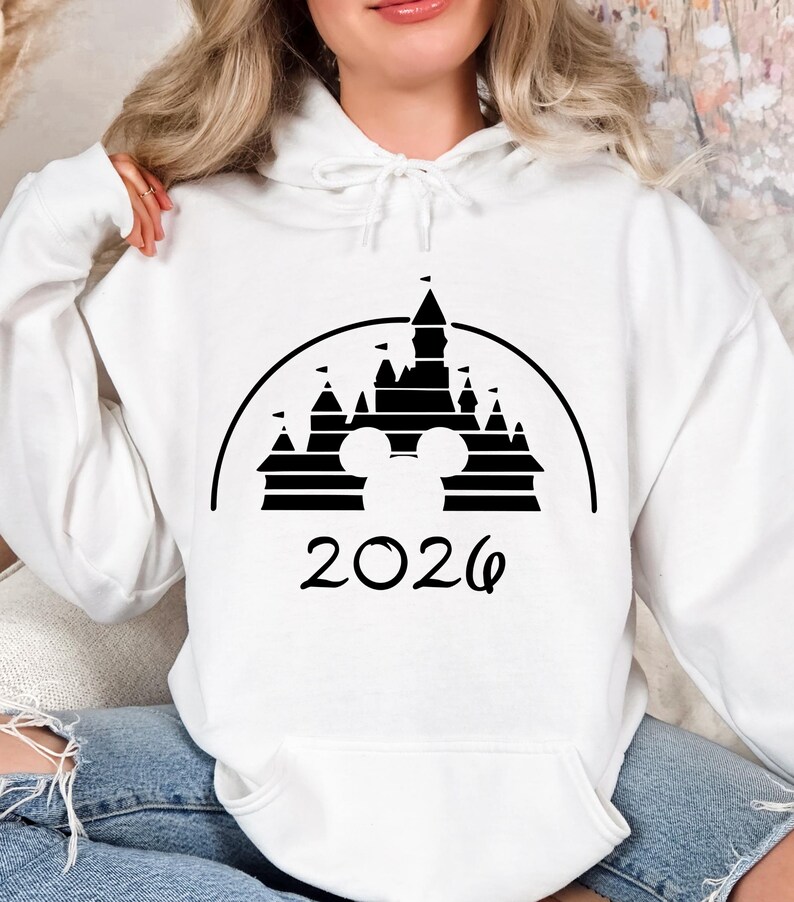 Puede incluir: Una taza de cer&aacute;mica blanca con asa negra y el texto "But First, Coffee" en negrita negra. La taza se encuentra sobre un fondo borroso, sugiriendo un ambiente acogedor.